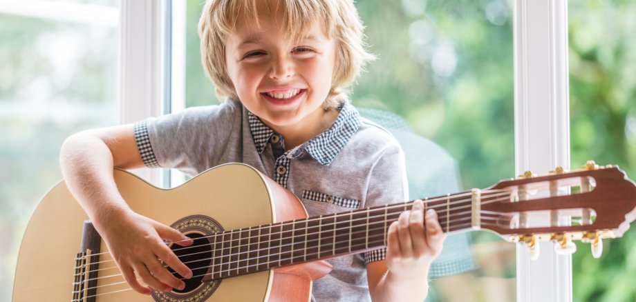 Happy,Smiling,Boy,Learning,To,Play,The,Acoustic,Guitar